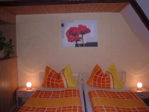 a bedroom with two beds and a painting on the wall at Maria Ferienhaus in Wernigerode