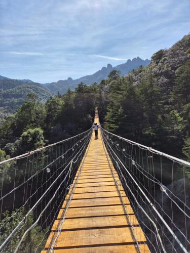 a person standing on a suspension bridge in the mountains at Chalet Cuarzo in Mineral del Chico