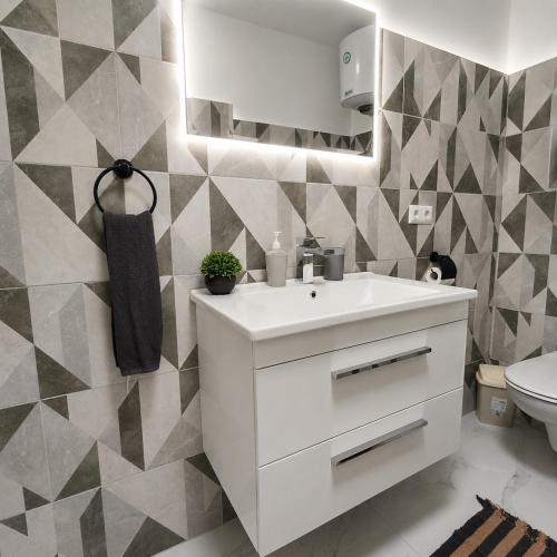 a bathroom with a white sink and a toilet at Rose 2 Apartment in Jajce