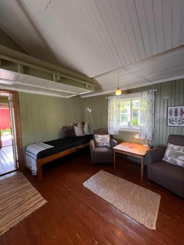 a living room with a bed and a couch at Cottage from 1850 in Ballstad in Ballstad