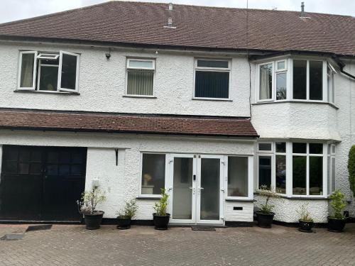 a white house with potted plants in front of it at Solihull Twin Room Wi-fi, TV in Solihull
