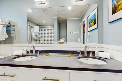 ein Badezimmer mit zwei Waschbecken und einem großen Spiegel in der Unterkunft Point Perfect in Port Madison