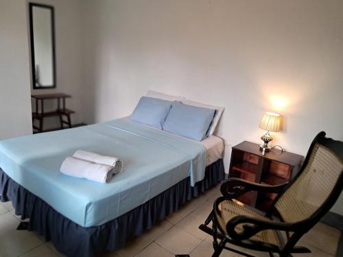 a bedroom with a bed with blue sheets and a chair at El Callejon Guest House in León