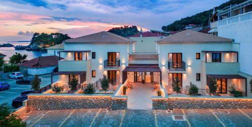 a large white house with a sunset in the background at Parga Gem K in Parga