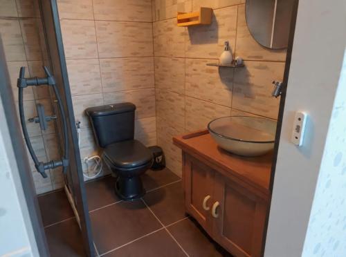a bathroom with a black toilet and a sink at Pousada Vettore in Atins