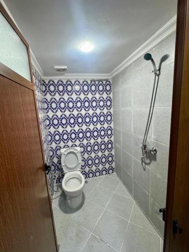 a bathroom with a toilet and blue and white tiles at Riad Al Anwar in Rabat