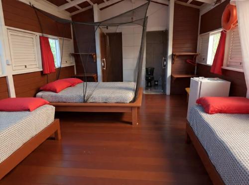 a room with three beds in a house at Pousada Vettore in Atins