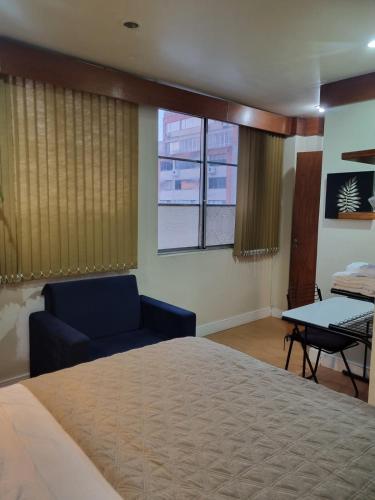 a bedroom with a bed and a couch and a table at Flora e Fauna in Porto Alegre