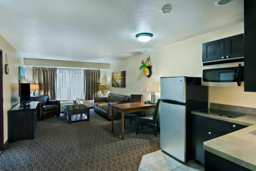 a hotel room with a kitchen and a living room at Oxford Suites Hermiston in Hermiston