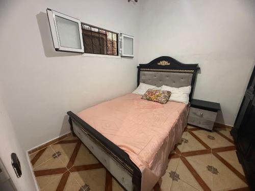 a small bedroom with a bed with a headboard at Katalan in Martil