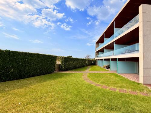 a hedge next to a building with a yard at T2 Dunas Esposende in Esposende
