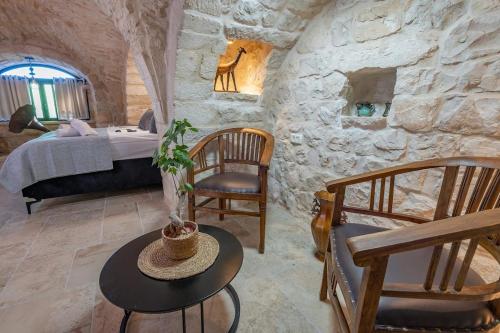 a bedroom with a bed and a stone wall at Tirat Ronit - טירת רונית in Safed