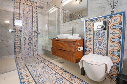 a bathroom with a shower and a toilet and a sink at Tirat Ronit - טירת רונית in Safed