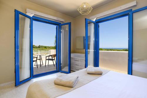a bedroom with a bed and sliding glass doors at Villa Kalymnos by Villa Plus in Kolymbia