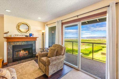 a living room with a fireplace and a view of the ocean at Hi-Tide Resort Queen Bed Unit 29 in Moclips