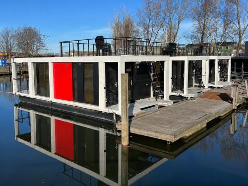 a house boat with a dock on the water at La Mare Resort in Gothenburg