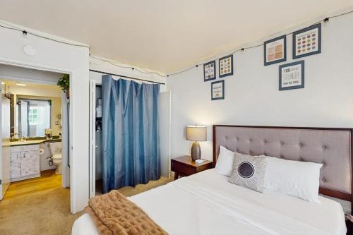 a bedroom with a large white bed and a bathroom at City Lights at Newmark - World Cup Availability in Seattle