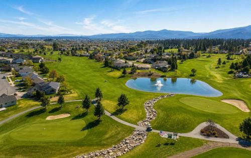 an aerial view of a golf course with a pond at Modern Loft Private Golf Course Retreat in Post Falls