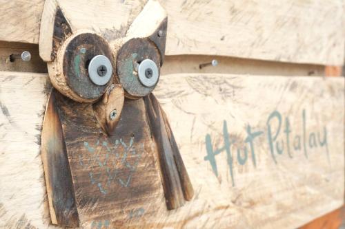 a metal object with eyes on a piece of wood at Little hut in Kampong Kundassan