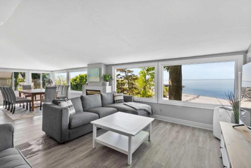 a living room with a couch and a table at Crystal Beach Waterfront Cottage - Sunset Views in Fort Erie