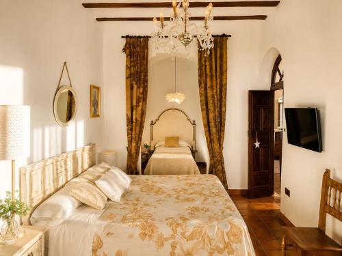 a bedroom with a bed and a chandelier at Las 9 Candelas alojamiento en el centro de Yecla in Yecla