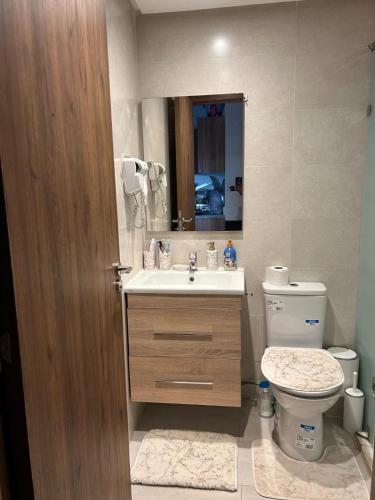 a bathroom with a sink and a toilet and a mirror at Diamond Blue in Sidi Rahal