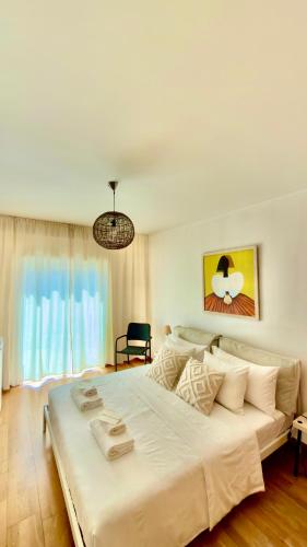 a large white bed in a room with a window at Ilumina Hostel Albufeira in Albufeira