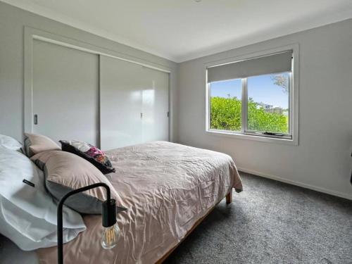 a bedroom with a large bed and a window at Snapper Cabin in Portland