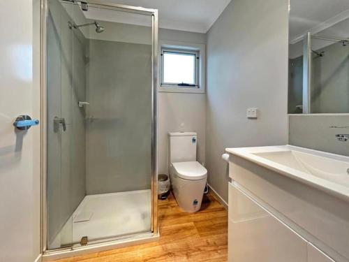 a bathroom with a shower and a toilet and a sink at Snapper Cabin in Portland