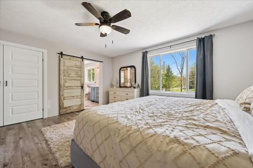 a bedroom with a bed and a ceiling fan at Larkwhistle Sauna Chickens Near BEACHES in Wiarton