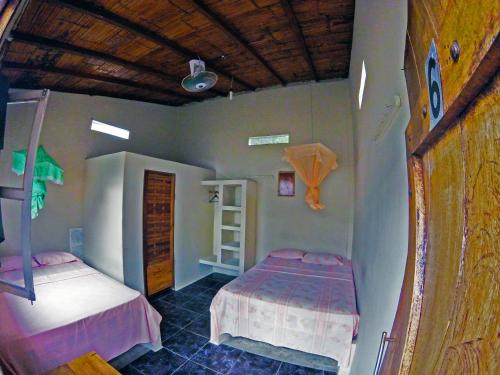 a bedroom with two beds and a wooden ceiling at Montañita Garden Hostal in Montañita