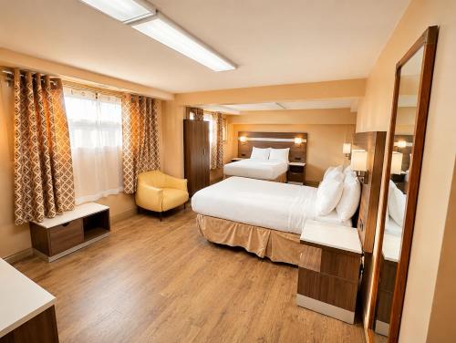 a hotel room with a large bed and a chair at Days Inn by Wyndham Fredericton in Fredericton