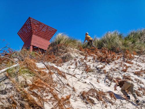 two men are climbing up a sand hill at Apartment on a holiday park in Blokhus in Blokhus
