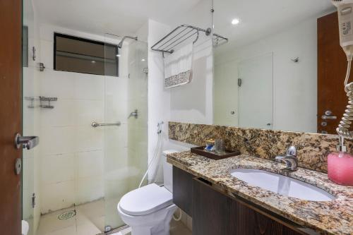 a bathroom with a sink and a toilet and a shower at Plaza Suíte Natal Vista Mar in Natal
