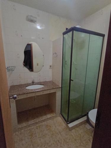 a bathroom with a sink and a glass shower at Hospedaria Clã do Cla in Arraial do Cabo