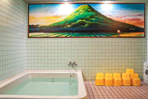 a bathroom with a tub and a painting on the wall at 美咲旅館 in Sakaide