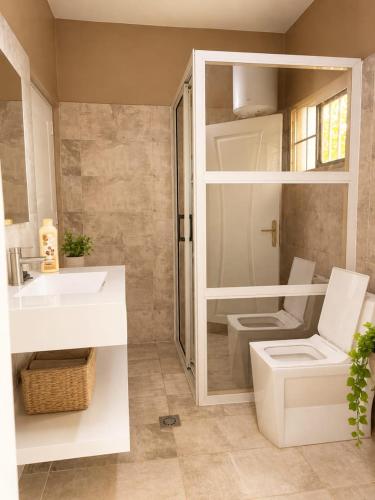 a bathroom with a white sink and a toilet at Kiki bay in Conakry