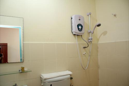 a shower in a bathroom with a toilet and a mirror at Sea Front Hotel Port Dickson in Port Dickson