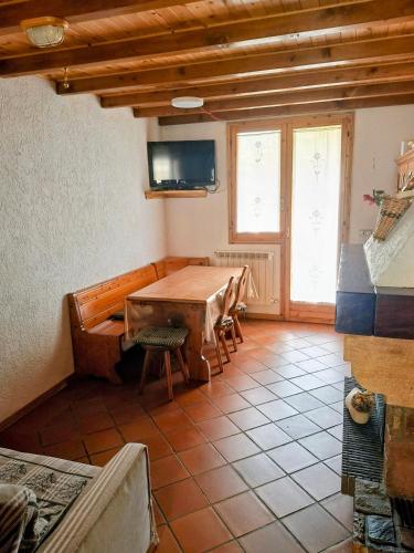 a dining room with a table and a tv at Casa vacanze Pievepelago in Pievepelago