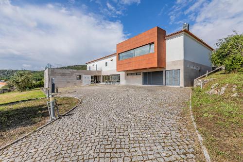 a house on a hill with a stone driveway at HI Alvados - Pousada de Juventude in Alvados
