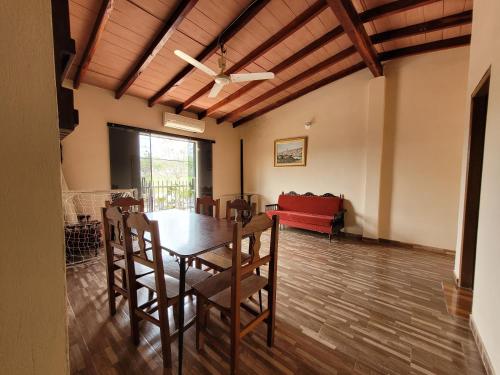 a dining room with a table and a red couch at Don Roque in Piribebuy