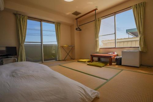 a bedroom with a bed and a large window at 美咲旅館 in Sakaide
