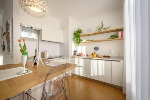 a kitchen with white cabinets and a wooden counter top at Royal Cadenabbia in Griante Cadenabbia