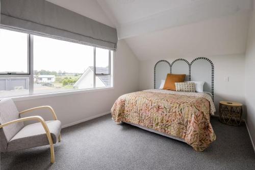 a bedroom with a bed and a chair and a window at The Stables in Newstead