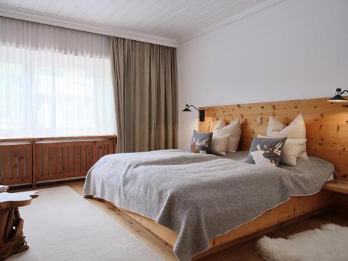 a bedroom with a large bed with a wooden headboard at Stadtchalet Forsthaus in Kitzbühel