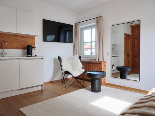 a living room with a chair and a mirror at Stadtchalet Forsthaus in Kitzbühel