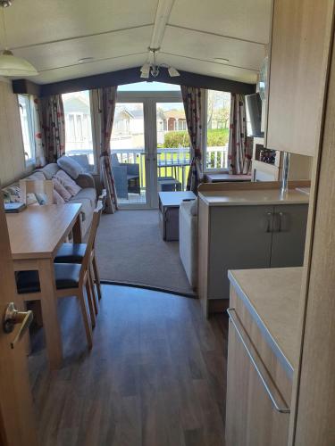 a kitchen and living room with a couch and a table at 3-Bed Caravan Sleeps 8 with Enclosed Decking in Fleetwood