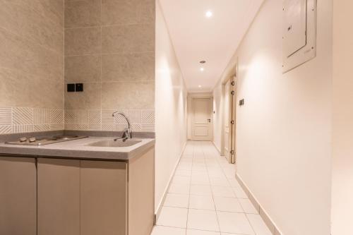 a kitchen with a sink and a hallway at عالم الضيافة in Al ‘Azīzīyah