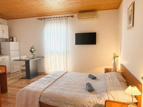 a bedroom with a bed and a desk and a television at Apartments and rooms by the sea Mandre, Pag - 3557 in Kolan