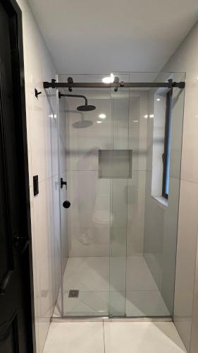 a shower with a glass door in a bathroom at CASA LAURA hotel & suites in Cuenca